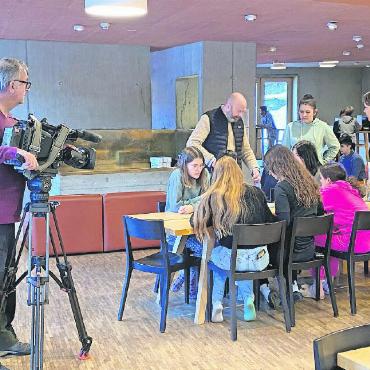 Erfolgreiches Brückenbauen über den Röstigraben - Schüler:innen bei einer gemeinsamen Gruppenarbeit. Ein Fernsehteam war auch vor Ort. FOTO: ZVG