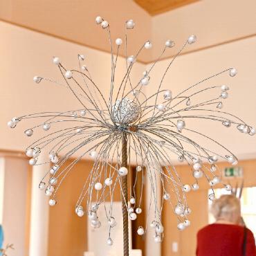 Kursausstellung mit Pusteblumen, Kräutertee und Seiltuch - Der Wind kann ihr nichts anhaben. Pusteblumen aus Eisenstab, Draht und Perlen sind sehr langlebige Kursprodukte.