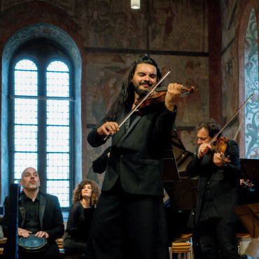 Weltreise mit Klang, Rhythmus und Gefühl - Der Künstler, vertieft in sein Spiel, das leidenschaftlich innig Bilder vor Augen führt, weltliche und sphärische Klänge erzeugt und Gefühle weckt. Sein  Ensemble schwingt im Gleichklang mit. (Foto: Raphael Faux)