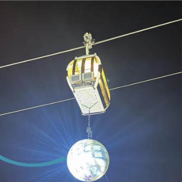 Zweite Ausgabe des Slopesound-Festivals findet Anklang - Eine überdimensionale Disco-Kugel hängt von einer Gondel herab und bietet dem Festivalgelände ein wahres Spektakel. FOTO: ELISA OPPERMANN