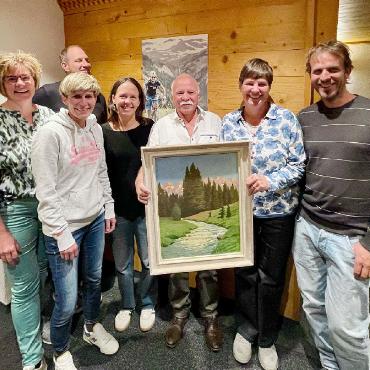 Zweiter Mösner-Stammtisch - Die Mitglieder der Dorforganisation Saanenmöser und Aschi Hodel mit dem Bild von Gottfried Lanz.