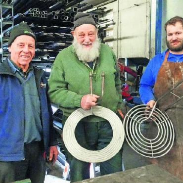 Ein «Ryter» eilt zu Hilfe - Bruno von Siebenthal (r.) zeigt einen Milchkühler Plani, wie er sie heute herstellt. Gottfried Ryter hält zufrieden sein «Urmodell» in der Hand und Michael Perreten (links) freut sich, dass die von ihm entwickelte Technik weiterhin verwendet wird. FOTO: VRENI MÜLLENER