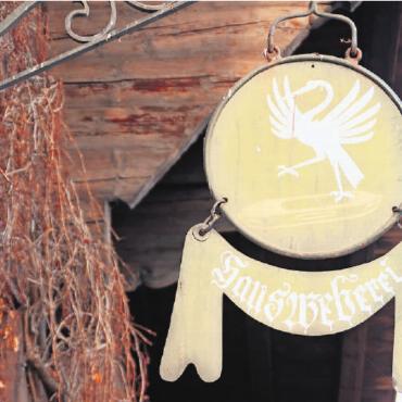 Mit dem Webschiffchen auf zu neuen Ufern - Das alte Schild am Eingang des Heimatwerks weist auf die einstige Hausweberei in Saanen hin. FOTO: KEREM MAURER