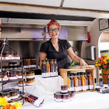 Sowohl Sonnenschein als auch Wind und Regen am Saaner Sommerfest - Die fröhliche Goldmedaillengewinnerin preist ihre Marmeladen an.