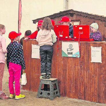 Mini-Gstaad 2025: So haben wir Kinder regiert - Nach getaner Arbeit gibt es erst einmal den Lohn bei der Bank.