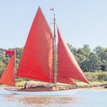 Der Gstaad Yacht Club kürt die Firefly zur Hundertjährigen des Jahres 2022 - Die Firefly mit dem roten, auffälligen Vierecksegel FOTO: ZVG