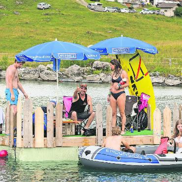 Tanz auf dem Wasser - Hauptsache es schwimmt: Festivalbesucher:innen haben ein gemütliches Floss mitgebracht.