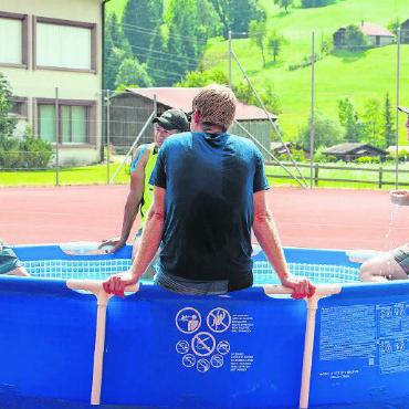 «One Team One Dream» siegen am 5. Kuederpesches Beachvolleyballturnier - Teilnehmende suchen Erfrischung im heiss begehrten Pool.