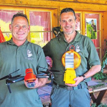 Jagd ist mehr als das Erlegen von Tieren - Tom Schild, Präsident des Jagd- und Wildschutzvereins Saanenland (rechts) und Johnny von Grünigen, Präsident der kantonalen Hegekommission, zeigen Utensilien wie das Wild von Strassenquerungen abgehalten werden kann, sowie eine Drohne zur Suche von Rehkitzen.
