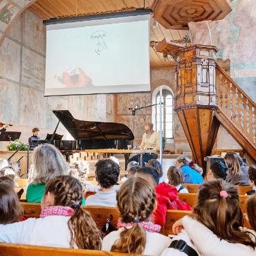 Viel Gefühl mit wenig Strichen - Die Schülerinnen und Schüler lauschten gespannt der Musik und folgten den Pinselstrichen des Künstlers.