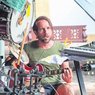 Wilde Akrobatik auf dem Gstaader Dorfbrunnen - Links: Jonas Zahnd spielt gleichzeitig Gitarre, Drums und singt die Begleitstimme.