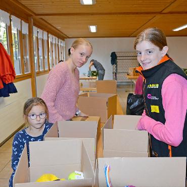 Ein Generationenprojekt der Herzlichkeit: Aktion Weihnachtspäckli - Von links: Elenya (7), Andrina (12) und Danja (14) packen fleissig mit an.