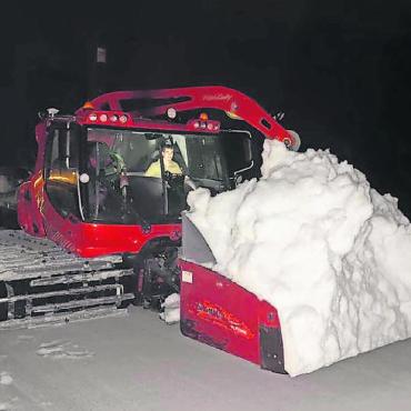 Mit Schaufeln, Baggern und viel Muskelkraft - Die BDG-Mitarbeitenden haben eine Traktor-Frontladeschaufel so umfunktioniert, dass sie auf ein Pistenfahrzeug passt. Dadurch konnten sie den Schnee in grösseren Mengen deutlich schneller transportieren als mit den Motorschubkarren.