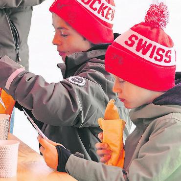 Swiss Ice Hockey Day auf dem Eisfeld in Gstaad - Nach getaner Arbeit in der Nässe war der Hotdog willkommen. FOTO: ERICH KÄSER