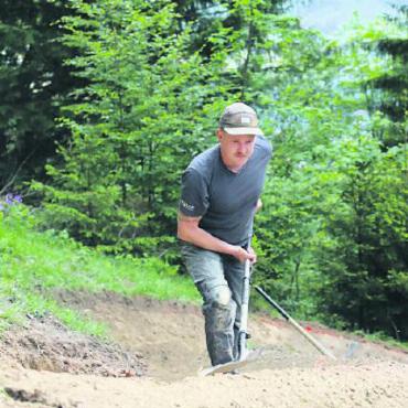 Mit dem Bike nicht länger über den Zaun - Nicht überall kann schweres Gerät eingesetzt werden. Trailbau ist auch Handarbeit, wie Sämi Brütsch zeigt.