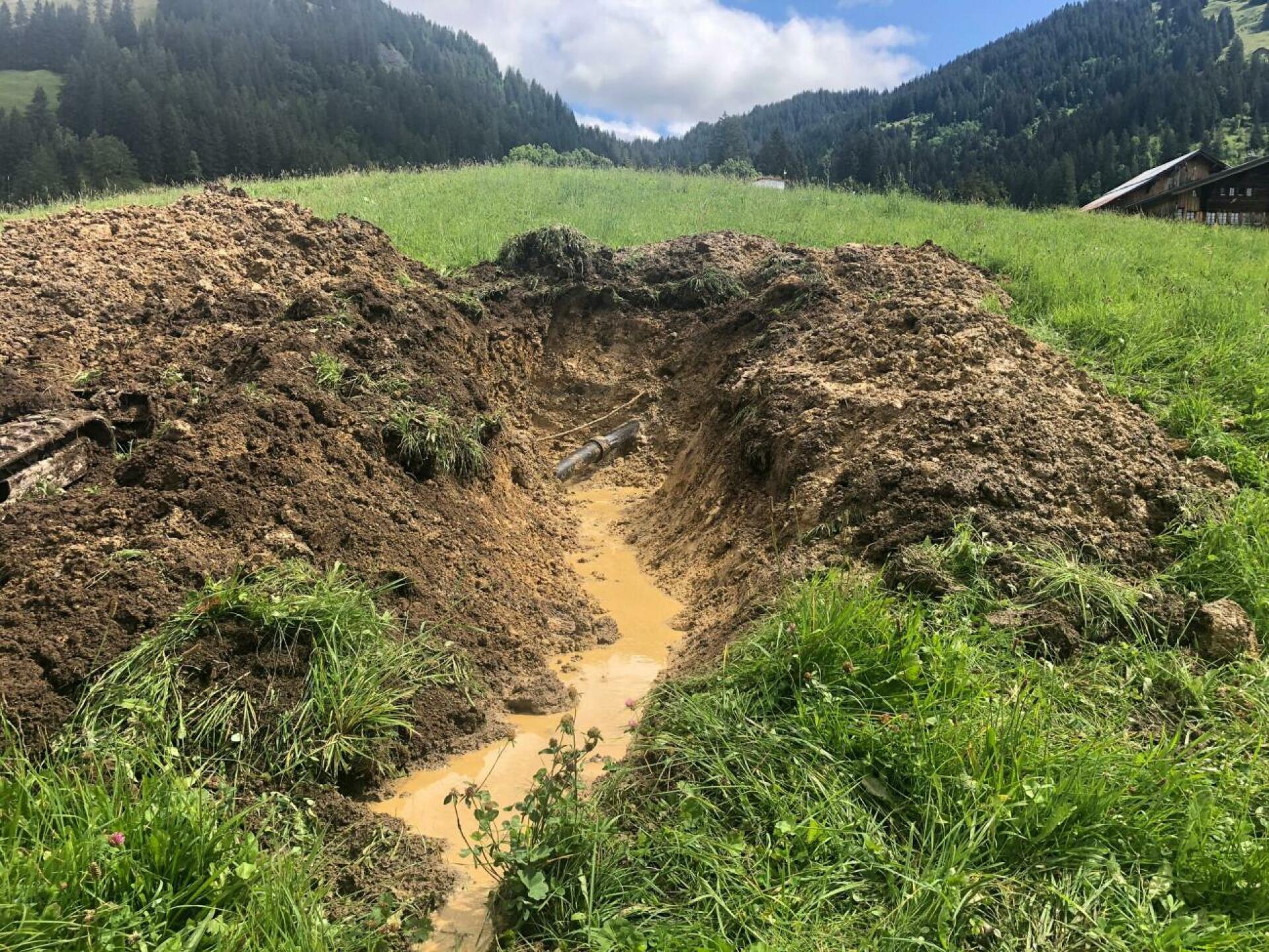 Offener Graben im Saali: Das Zementfaserohr der Hauptwasserleitung erlitt in den letzten Jahren immer wieder Leitungsbrüche. (Foto: Gemeinde Gsteig/Ruedi Kistler)
