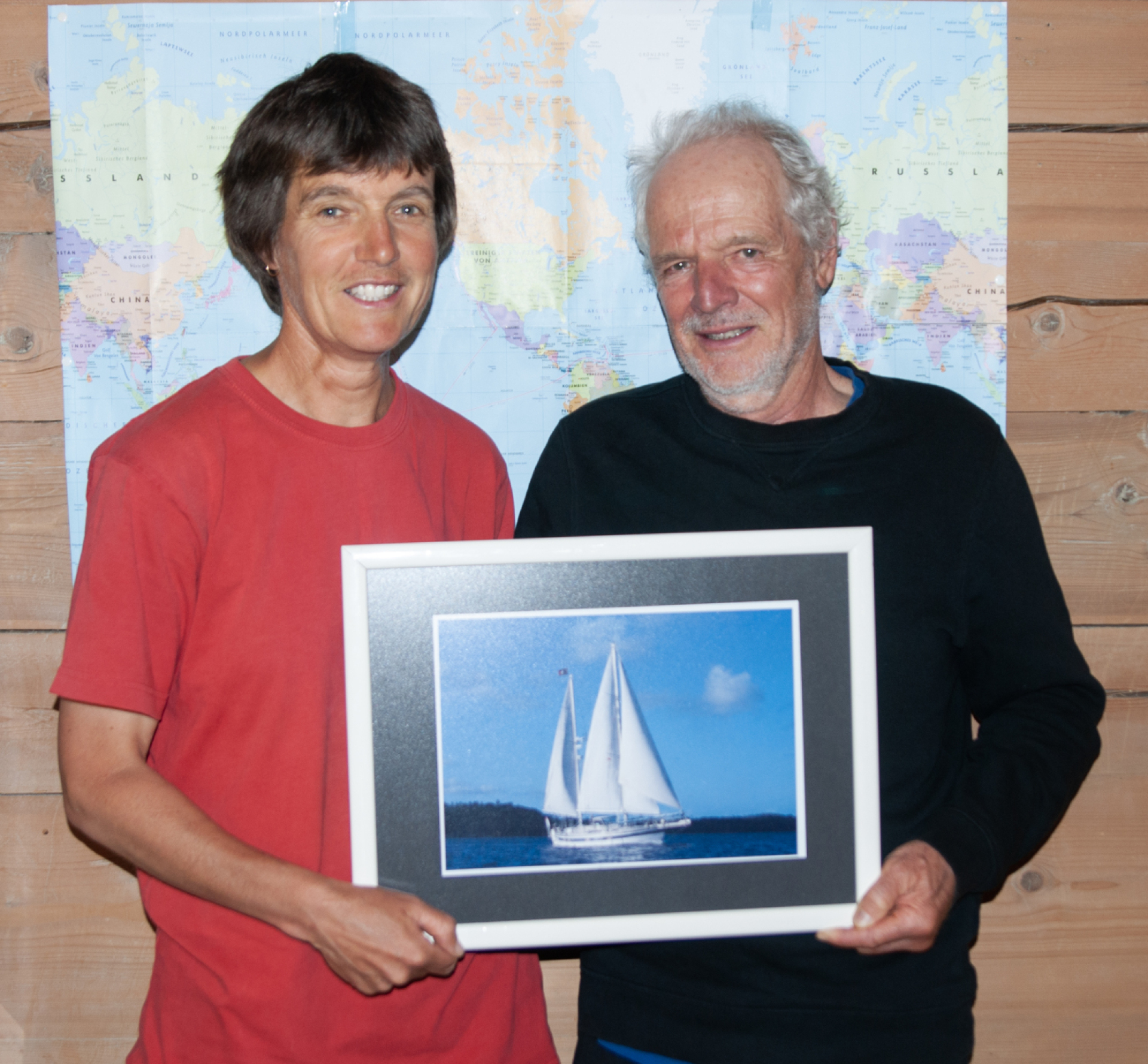 Silvia Widmer und Rolf Wey mit einem Bild ihrer Segelyacht Betonia vor einer Weltkarte, auf der sie Ihre gesegelten Routen eingetragen haben. (Fotos: AvS und zvg)