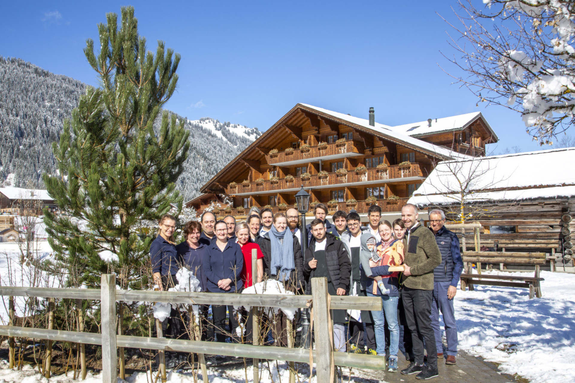 Das komplette Team des Hotels Alpenland mit Gästen und den Vertretern des Nachhaltigkeitslabels Ibex Fairstay. Links im Bild: Der frisch gepflanzte Bergkiefer, der symbolisch für die nachhaltige Zukunft des Hotel steht. (bFotos: AvS)