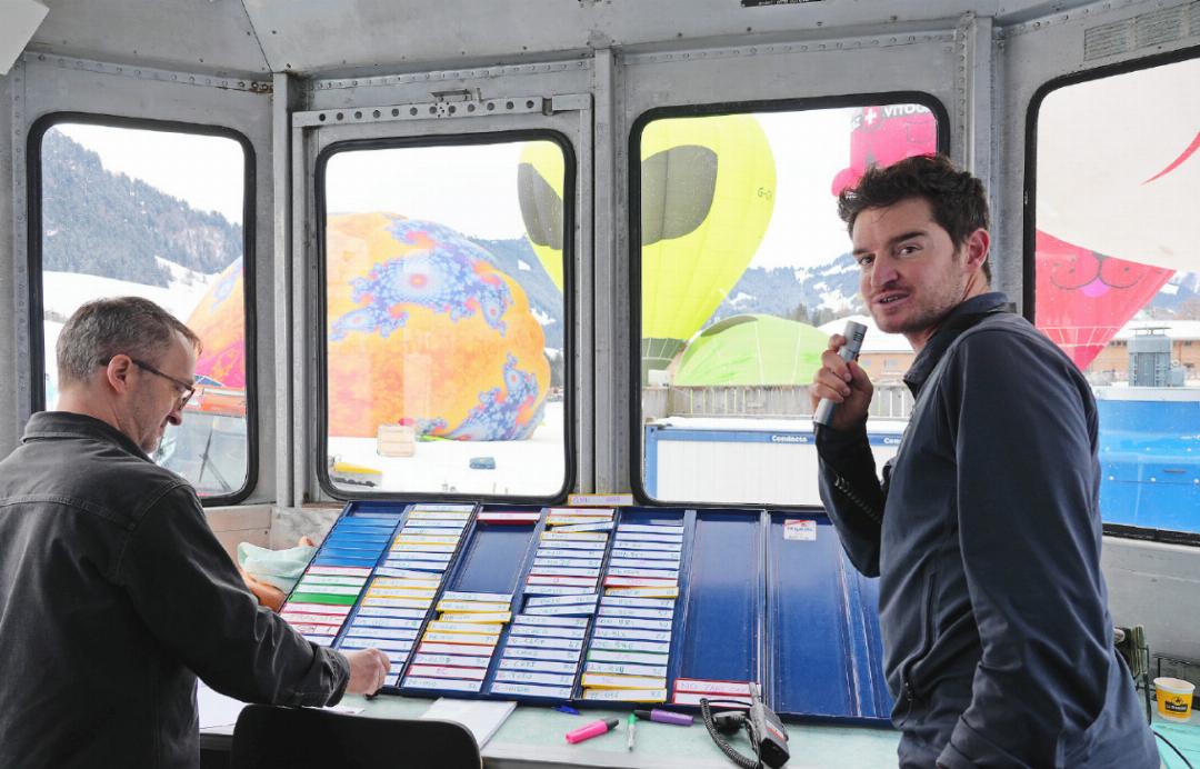 Im provisorischen Kontrollraum behält Fluglotse Bastien Bonelli und seine Kollegen den Überblick über alle Ballone. Auf dem Tableau sind die Ballone nach ihren internationalen Funkkennungen geordnet: HB steht für Schweizer Ballone, F für Frankreich, G für Grossbritannien, OO für Belgien oder PT für Brasilien. Mit einem «C» markieren die Fluglotsen jene Ballone, die per Funk in Kontakt mit den Fluglotsen stehen. Ein farbiger Strich zeigt an, welche Ballone tatsächlich abgehoben sind. So ist auf einen Blick ersichtlich, wer gestartet ist – und am Abend, ob auch alle wieder sicher gelandet sind. Im provisorischen Kontrollraum behält Fluglotse Bastien Bonelli und seine Kollegen den Überblick über alle Ballone. Auf dem Tableau sind die Ballone nach ihren internationalen Funkkennungen geordnet: HB steht für Schweizer Ballone, F für Frankreich, G für Grossbritannien, OO für Belgien oder PT für Brasilien. Mit einem «C» markieren die Fluglotsen jene Ballone, die per Funk in Kontakt mit den Fluglotsen stehen. Ein farbiger Strich zeigt an, welche Ballone tatsächlich abgehoben sind. So ist auf einen Blick ersichtlich, wer gestartet ist – und am Abend, ob auch alle wieder sicher gelandet sind.