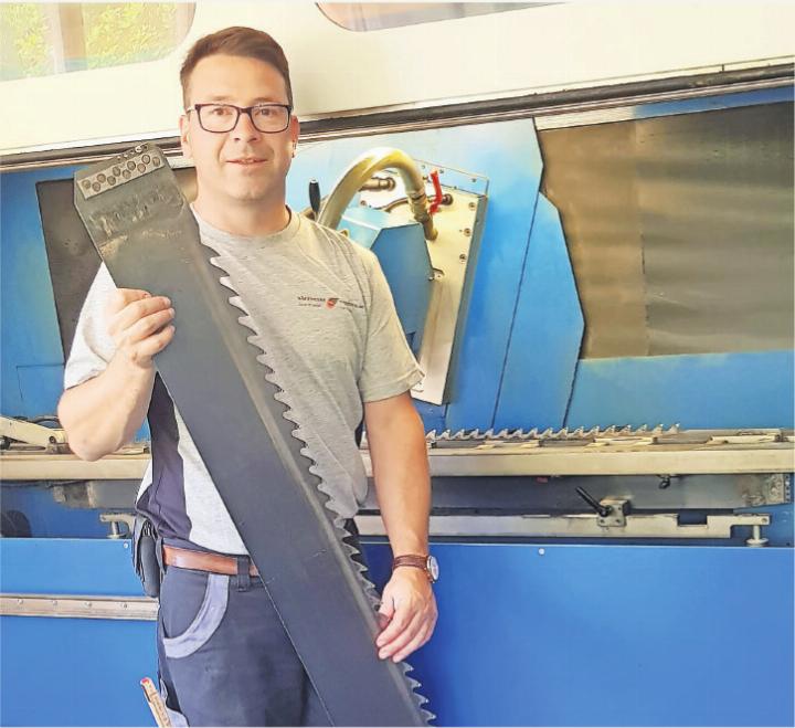 André Albisser, mit einem Sägeblatt, das im Vollgattersägewerk Rundholz fräst.