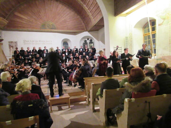 Die Kirche Zweisimmen, mit ihrer gewölbten Holzdecke eignet sich akustisch sehr gut für ein Chorwerk, und auch visuell kommen die Konzertbesucher auf ihre Rechnung. Wunderschön binden sich das Kammerorchester und der Chor mit den Solisten in das Kirchenchor mit der dekorativen Rosette im Hintergrund. 