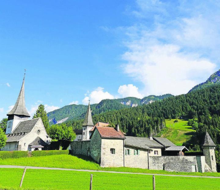 Die Kirche Saint-Nicolas in Rougemont, erbaut um ca. 1080 im romanischen Stil. Das nach Simmentaler Art gebaute, steile Kirchendach mit den Lukarnen wurde im 16. Jahrhundert erstellt. Rechts das Schloss, das man auf den Fundamenten des alten Klosters baute. Es diente ab 1575 dem Berner Landvogt als Residenz. Seit 1803 ist es in Privatbesitz. FOTOS: MARTIN GURTNER-DUPERREX