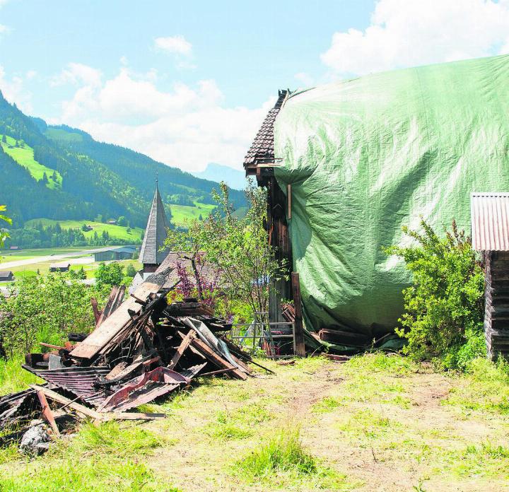 Verbranntes aufgestapeltes Holz, eingepacktes Haus: Das Gebäude nach dem Brand. FOTO: KEREM MAURER