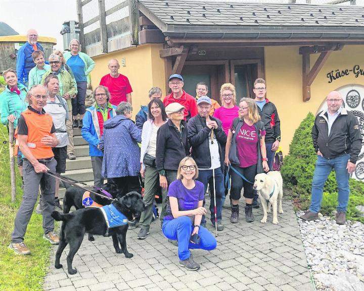 Die Blinden und Sehbehinderten beim König des Käses in der Käsegrotte: kniend Daniela Borter, links mit Hund Daniel Borter, rechts René Ryser, Geschäftsführer Molkerei Gstaad. FOTO: ZVG