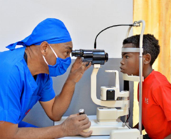 Der Augenchirurg prüft Oscars Augen vor der Operation. FOTO: CBM/RAKOTOARIVONY