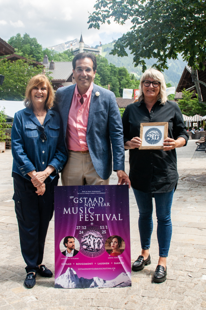 Prinzessin Caroline Murat (links), künstlerische Leiterin und Gründerin des Gstaad New Year Music Festivals, mit Çetin Köksal, administrativer Leiter, mit dem neuen Plakat. Regina Martin (rechts)  kreierte den  Scherenschnitt für das neue Logo. (Foto: AvS)