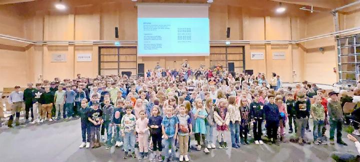 «eifachBen» mit den singenden Schülerinnen und Schülern in der Simmental Arena. FOTO: MADLAINA CAVIEZEL