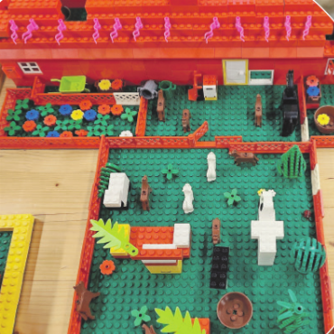 Eine ganze Woche Spiel und Spass im Rüttischulhaus - Ein Garten mit einem wilden Blumenbeet und verschiedenen Tieren.