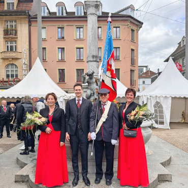 Zwei Topplatzierungen am EMF 2026 für die Brass Band «Harmonie» Saanen und die Musikgesellschaft Gstaad - Der Dirigent der MGG, Sandro Frautschi, umgeben von den Ehrendamen und dem Vereinsfähnrich.